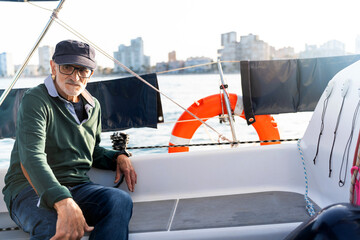 Senior man enjoying a relaxing sailing trip on sailboat