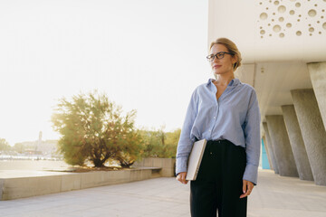 A Confident Professional Woman in a Modern Architectural Setting, Exuding Achievement