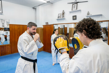 Karate athletes training punches and kicks in dojo