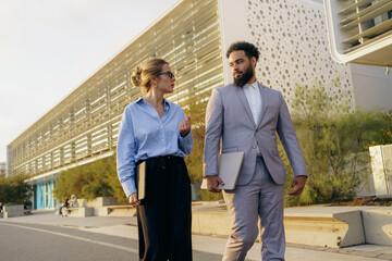 A group of professional colleagues is seen walking together in an urban environment today