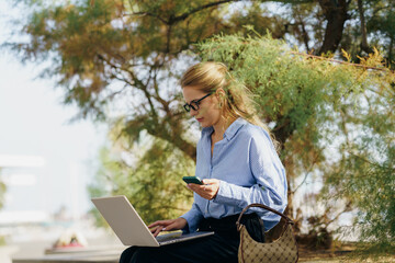A Professional Woman Engaged in Work While Embracing the Beauty of Nature with Her Laptop and Phone