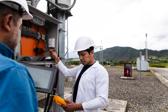 Engineers conducting transformer voltage check at a wind farm