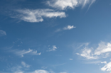 Wispy cirrus clouds drifting across a vibrant blue sky