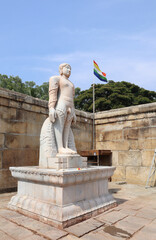 The Statue of Jain Monk lord Bahubali sculptured in grey stone with intricate carvings in a Jain...