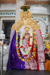 Goddess Padmavati sculptured in Pure gold, decorated with flowers at a Jain temple and worshiped...