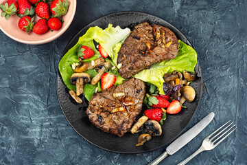 Piece of roast beef with strawberries.