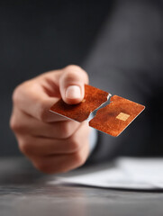 A person breaks a payment card in half, symbolizing debt freedom, financial control, or cancellation. Perfect for illustrating finance articles, blogs,  responsible spending.