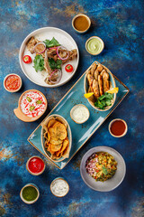 Several dishes of chicken, fish, potatoes, various salads and sauces.