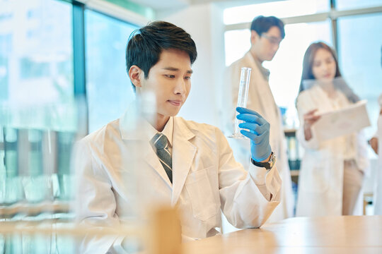 Young Asian Men and Women Scientists Collaborating in Modern Laboratory