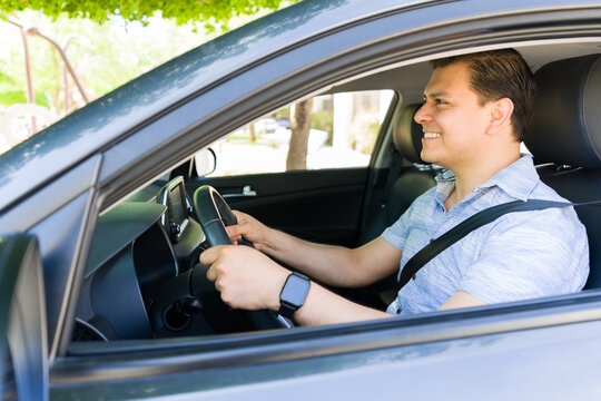 Happy man driving modern car in the city