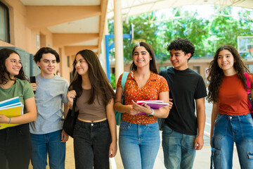 Happy high school students walking and talking together