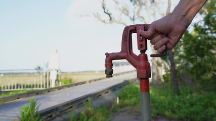 Water Spigot near a tidal marsh slow motion water flow on a bright day - Powered by Adobe