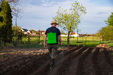 Farmer spraying fertilizer.  Pest control and plant diseases to obtain a large harvest