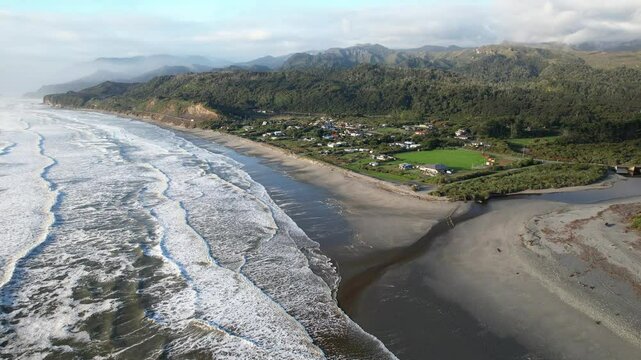 Davy Creek Flowing To The Sea With Rapahoe Village In West Coast, New Zealand. - aerial shot