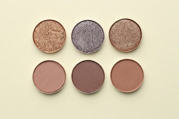 Beautiful eyeshadow refill pans on beige background, flat lay