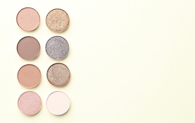 Beautiful eyeshadow refill pans on beige background, flat lay. Space for text