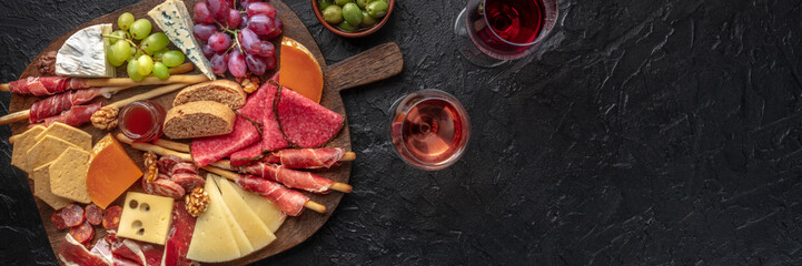 Antipasti or tapas. Charcuterie and cheese board with wine, overhead flat lay panorama with copy space