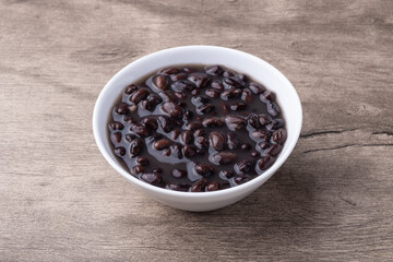 Cooked black beans in a bowl over wooden table