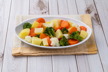 Cooked vegetables in a plate over wooden table