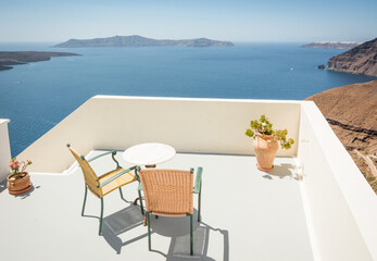 Table for two on the cliff of Santorini island. Cafe table with two chairs with a view from Thera village at Cyclades islands. 