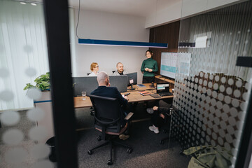 A group of associates engaged in a productive meeting within a contemporary office setting, highlighting active discussions, teamwork, and business analysis.