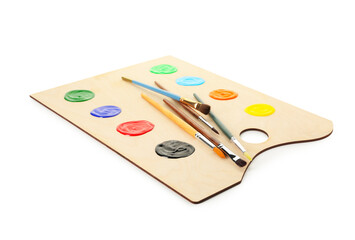 Wooden palette with paints and brushes isolated on white