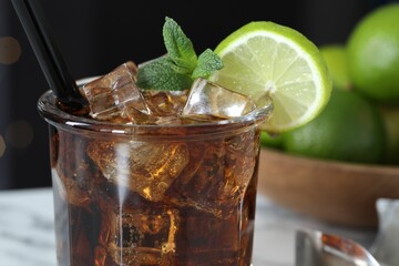 Tasty Cuba Libre cocktail in glass on table, closeup