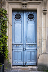 Beautiful vintage blue wooden  and metal doors set in a stone wall, close up