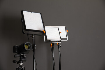 Professional lighting equipment and camera on grey background