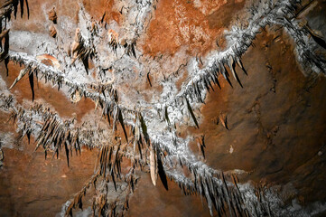 Interior of cave decorated with stalactite. Stone and rock formations in cave. Mineral and crystal...