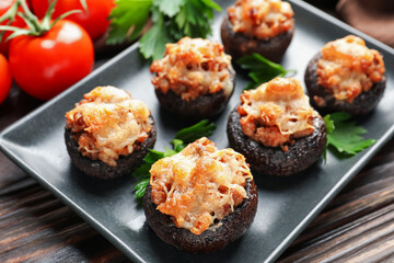 Delicious stuffed mushrooms with parsley on wooden table, closeup