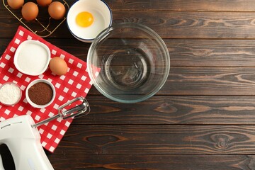 Making whipped cream. Bowl, whisk and ingredients on wooden table, flat lay. Space for text