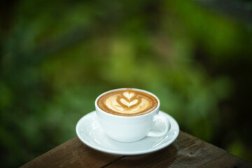 Background Coffee cup and beans on old kitchen table. Hot art Latte Coffee.
