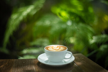 Background Coffee cup and beans on old kitchen table. Hot art Latte Coffee.
