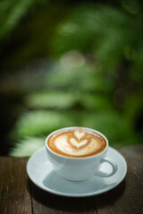 Background Coffee cup and beans on old kitchen table. Hot art Latte Coffee.
