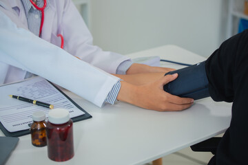 Female doctor gives advice and explains to patient for annual health check in examination room by...