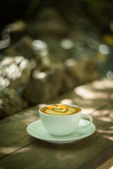 Background Coffee cup and beans on old kitchen table. Hot art Latte Coffee.
