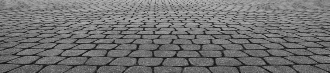 new modern gray stone cobbled street road pavement texture. background backdrop in perspective. tiled floor flooring. grey tile.