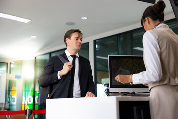 receptionist at desk in airport : Hispanic woman receptionist helping traveler with passport for...