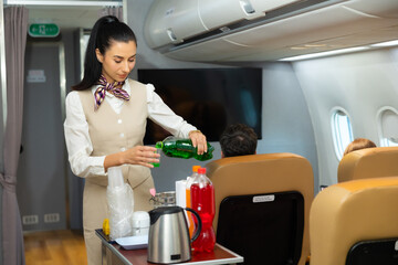 working serving drinks : Stewardess Cabin crew or air hostess working in airplane cabin. Caucasian Female steward serving glass of water for passengers on board. Flight attendant and Cart on airplane