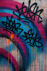 Vibrant pink & blue spray-painted arches with black graffiti tags on a textured brick wall. Dripping paint. Urban street art, expressive & raw.