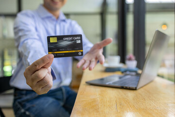 A man is using a laptop to pay for something with a credit card. Concept of convenience and ease, as the man is able to complete his transaction quickly and easily using his laptop
