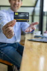 A man is using a laptop to pay for something with a credit card. Concept of convenience and ease, as the man is able to complete his transaction quickly and easily using his laptop
