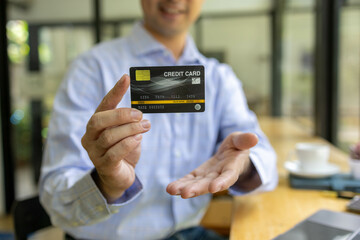 A man is using a laptop to pay for something with a credit card. Concept of convenience and ease, as the man is able to complete his transaction quickly and easily using his laptop
