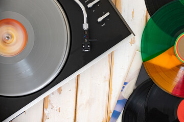 Vintage record player spinning a vinyl record with tone arm and needle. Top view.