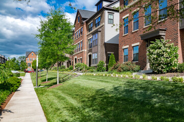 row of Modern multi-family townhouses with landscaping.