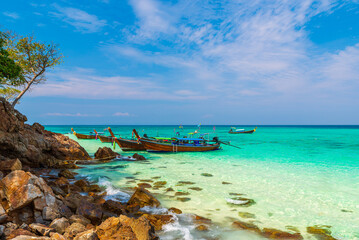 Turquoise clear water and traditional wooden boat in Bamboo island, Phi Phi, Thailand