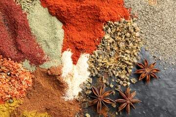 Many different spices on dark table, flat lay