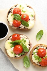 Tasty stuffed mushrooms served on light table, top view