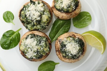 Tasty stuffed mushrooms on plate, top view